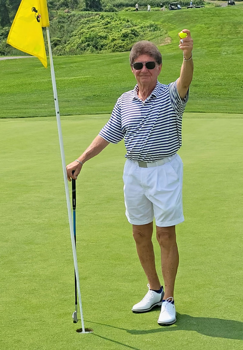 Harry Jacob holding up his ball at the flagstick